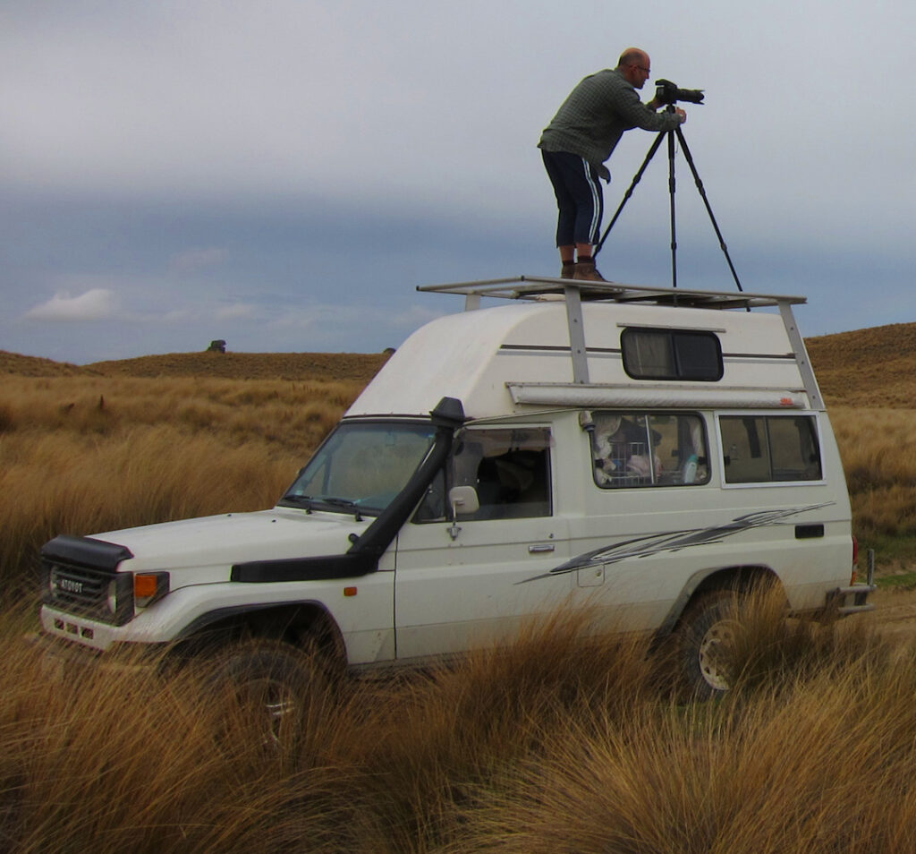 Photographer using a tripod on top of a Series 70 Land Cruiser camper truck